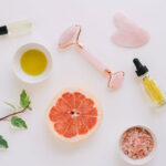 Graphic of essential oils, grapefruit and rose quartz massage roller.